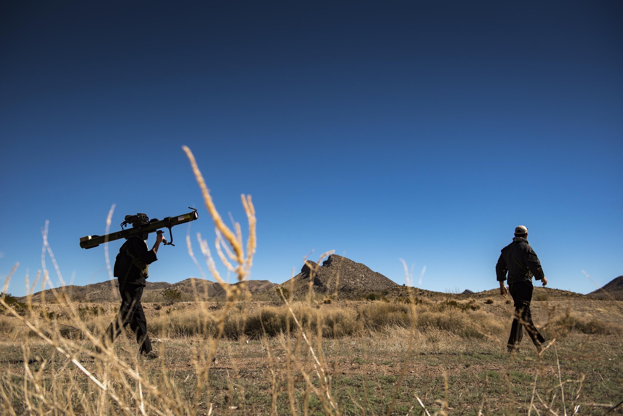 Senior Airman Keaton Houser, left, and Tech. Sgt. Mykal Seqeuria, 563d Operations Support Squadron, use a man-portable, aircraft survivability trainer to simulate threats on an aircraft, Feb. 22, 2017, at the Playas Training and Research Center, N.M. OPFOR is a role designed to simulate downrange threats and complicate training objectives with the ultimate goal of creating a realistic training environment for units preparing to deploy. Airmen from the 563d OSS fill this role in support of numerous joint exercises each year utilizing aircraft-threat emittors, vehicle-mounted simulation weapons and waves of ground troops. (U.S. Air Force photo by Staff Sgt. Ryan Callaghan)