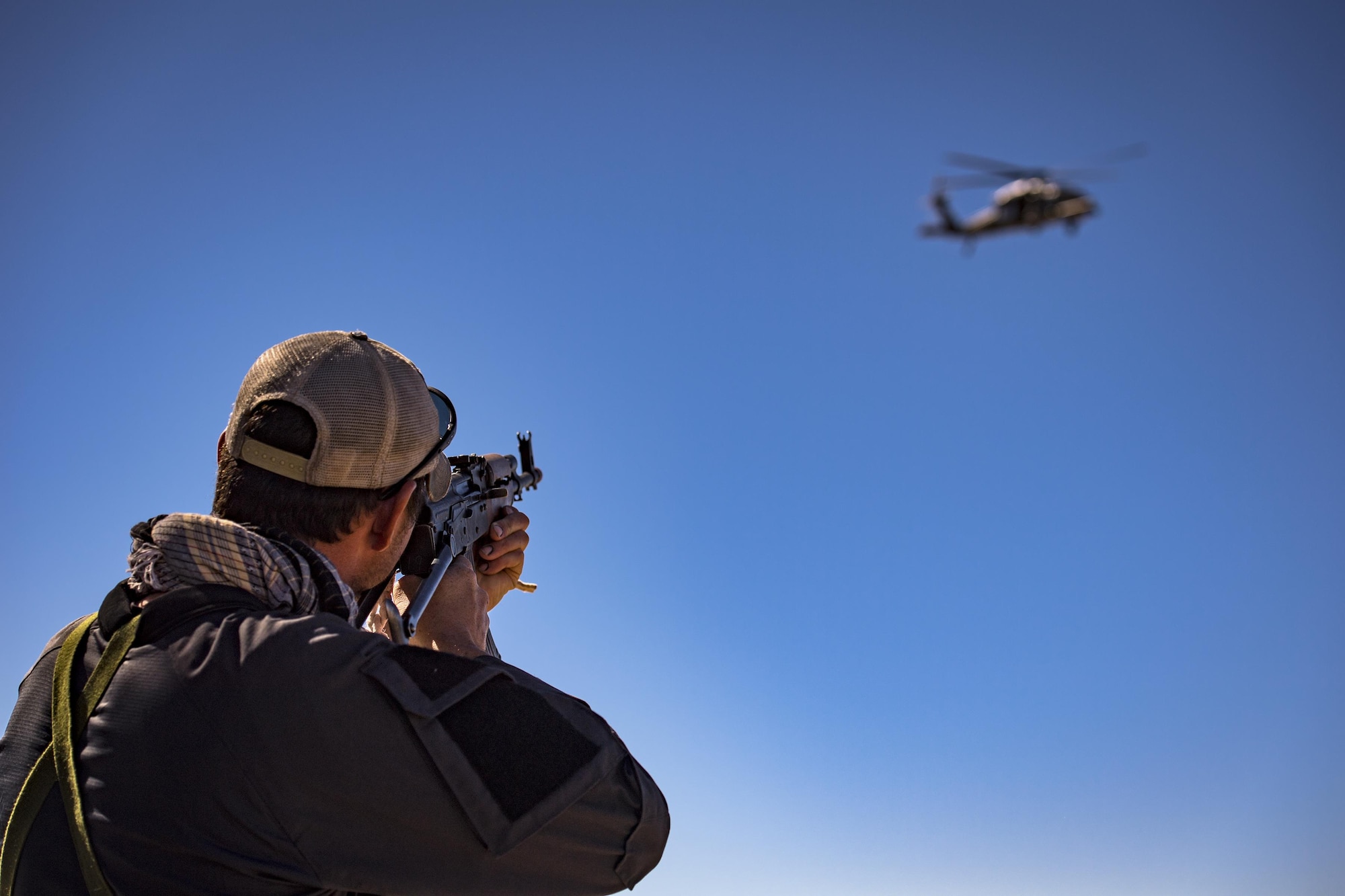 Tech. Sgt. Mykal Sequeria, 563d Operations Support Squadron rigger, targets an HH-60G pave Hawk while acting as an oppositional force member, Feb. 22, 2017, at the Playas Training and Research Center, N.M. OPFOR is a role designed to simulate downrange threats and complicate training objectives with the ultimate goal of creating a realistic training environment for units preparing to deploy. Airmen from the 563d OSS fill this role in support of numerous joint exercises each year utilizing aircraft-threat emittors, vehicle-mounted simulation weapons and waves of ground troops. (U.S. Air Force photo by Staff Sgt. Ryan Callaghan)