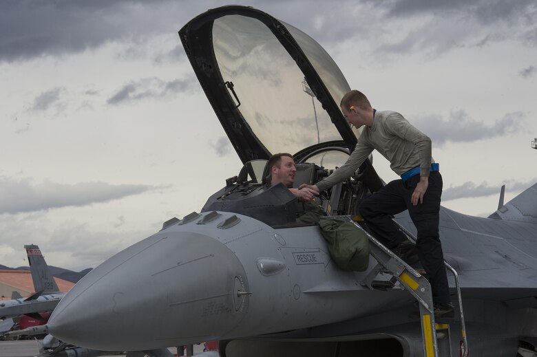 U.S. Air Force Maj. James Nicholas, 55th Fighter Squadron pilot, left, shakes hands with Airman Bryce Gavitt, 55th FS crew chief, right, before taking off in support of Red Flag 17-2 at Nellis Air Force Base, Nev., Feb. 27, 2017. Red Flag provides a series of intense air-to-air scenarios for aircrew and ground personnel, aiming to increase their combat readiness and effectiveness for future real-world missions. (U.S. Air Force photo by Senior Airman Zade Vadnais)