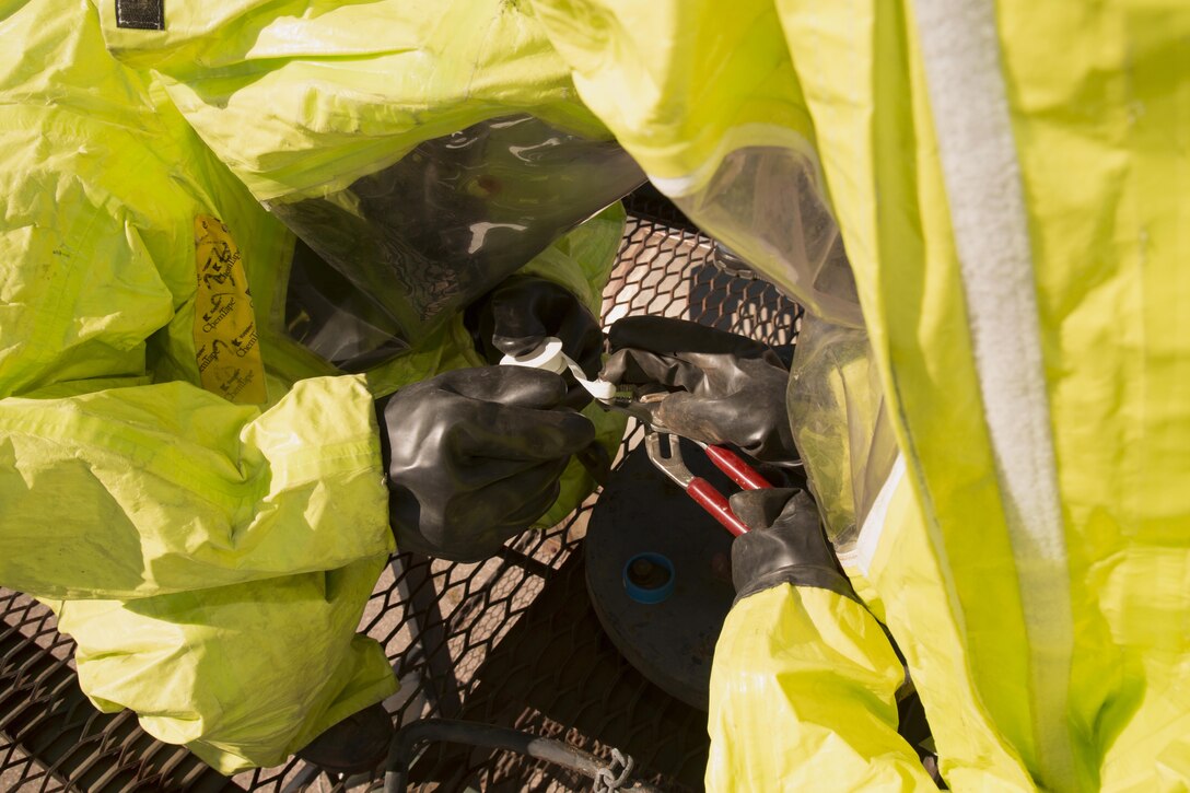 Firefighters work together in full protective gear to remove and replace faulty equipment, to include wrapping delicate plumber's tape which proved tricky in the thick rubber gloves, during hazardous materials response training held aboard Marine Corps Logistics Base Barstow, Calif., Feb. 15.