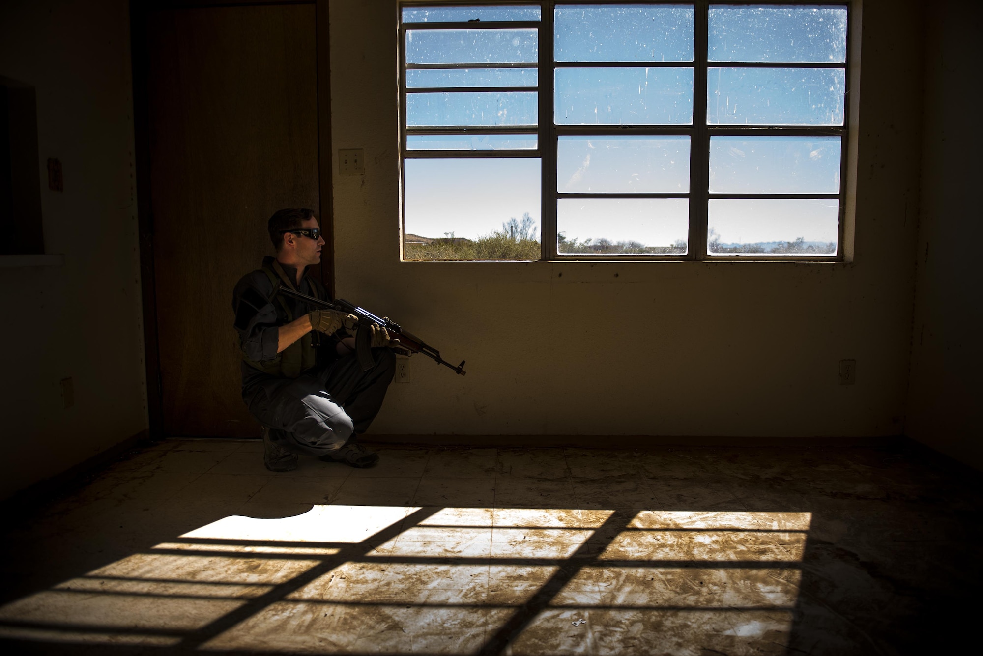 Staff Sgt. Eric Fullmer, 563d Operations Support Squadron, scans through a window while acting as an oppositional force member, Feb. 22, 2017, at the Playas Training and Research Center, N.M. OPFOR is a role designed to simulate downrange threats and complicate training objectives with the ultimate goal of creating a realistic training environment for units preparing to deploy. Airmen from the 563d OSS fill this role in support of numerous joint exercises each year utilizing aircraft-threat emittors, vehicle-mounted simulation weapons and waves of ground troops. (U.S. Air Force photo by Staff Sgt. Ryan Callaghan)