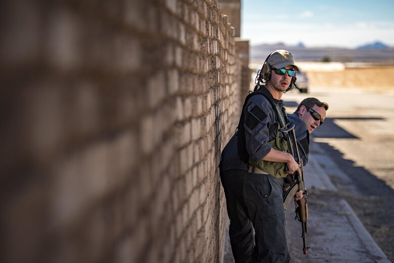 Senior Airman Shane Hardin, left, and Staff Sgt. Eric Fullmer, 563d Operations Support Squadron, scan for targets while acting as oppositional forces, Feb. 22, 2017, at the Playas Training and Research Center, N.M. OPFOR is a role designed to simulate downrange threats and complicate training objectives with the ultimate goal of creating a realistic training environment for units preparing to deploy. Airmen from the 563d OSS fill this role in support of numerous joint exercises each year utilizing aircraft-threat emittors, vehicle-mounted simulation weapons and waves of ground troops. (U.S. Air Force photo by Staff Sgt. Ryan Callaghan)