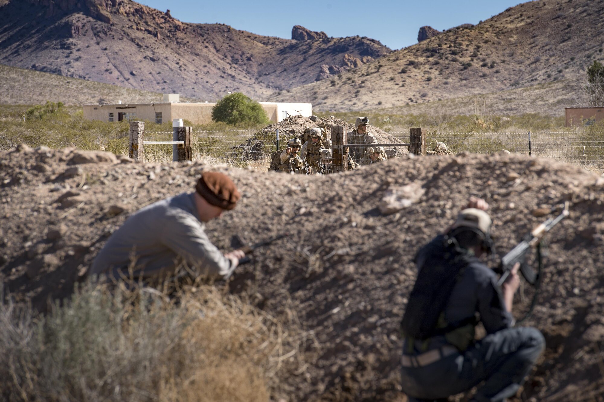 Airmen from the 563d Operations Support Squadron engage a group of Marines from I Marine Expeditionary Force while acting as oppositional forces, Feb. 22, 2017, at the Playas Training and Research Center, N.M. OPFOR is a role designed to simulate downrange threats and complicate training objectives with the ultimate goal of creating a realistic training environment for units preparing to deploy. Airmen from the 563d OSS fill this role in support of numerous joint exercises each year utilizing aircraft-threat emittors, vehicle-mounted simulation weapons and waves of ground troops. (U.S. Air Force photo by Staff Sgt. Ryan Callaghan)