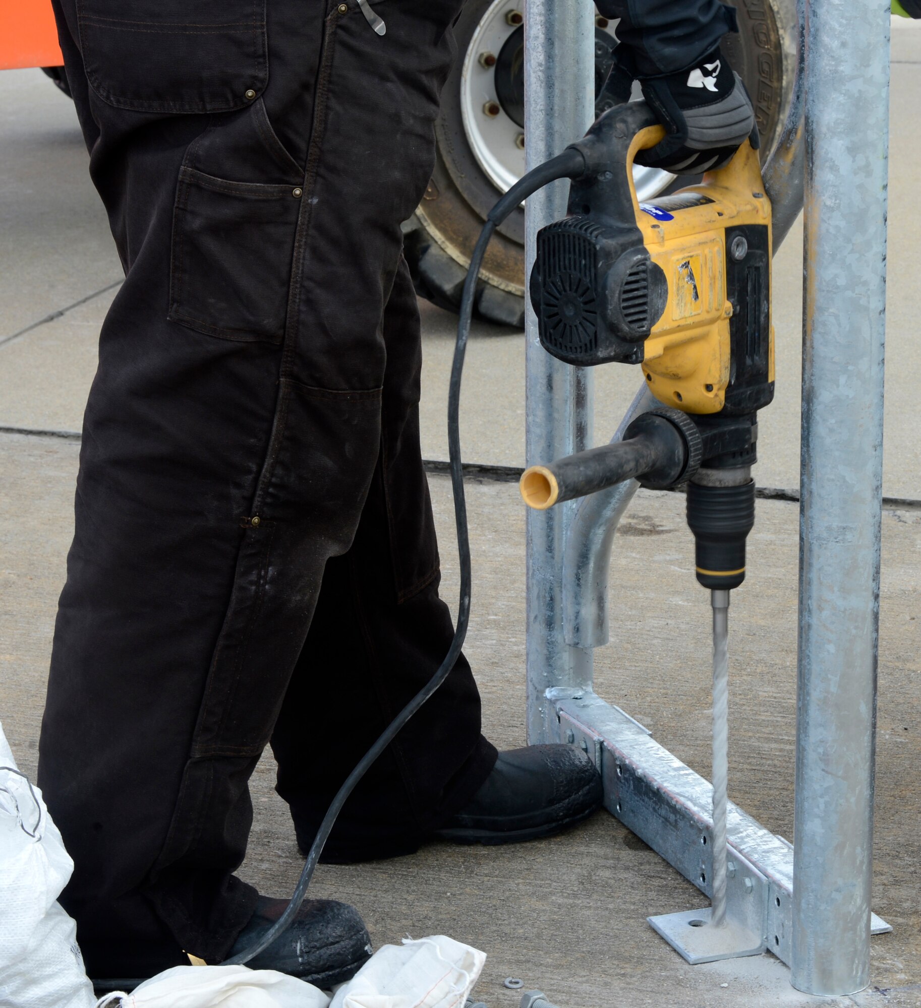 Ricky Bass, Big Top Manufacturing Company lead technician, drills a hold to secure a support beam for a sun shade at Joint Base Langley-Eustis, Va., Jan. 12, 2017. The 18 sun shades on the flight line will allow the 1st Fighter Wing aircraft mechanics more space to work on the F-22 Raptors.  (U.S. Air Force photo by Airman 1st Class Kaylee Dubois)