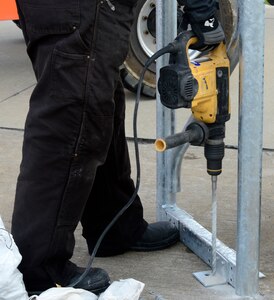 Ricky Bass, Big Top Manufacturing Company lead technician, drills a hold to secure a support beam for a sun shade at Joint Base Langley-Eustis, Va., Jan. 12, 2017. The 18 sun shades on the flight line will allow the 1st Fighter Wing aircraft mechanics more space to work on the F-22 Raptors.  (U.S. Air Force photo by Airman 1st Class Kaylee Dubois)
