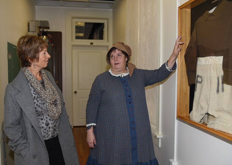 Paula Taylor, 90th Missile Wing base museum director, tells the story of a prisoner of war outfit to Laura Hyten, wife of Gen. John E. Hyten, U.S. Strategic Command commander, at the Warren ICBM & Heritage Museum on F.E. Warren Air Force Base, Wyo., Feb. 22, 2017. Mrs. Hyten toured the base to meet with Airmen and families of the Mighty Ninety, and learned about the base’s rich history as it approaches its 150th anniversary, July 4, 2017. (U.S. Air Force photo by Glenn S. Robertson)

