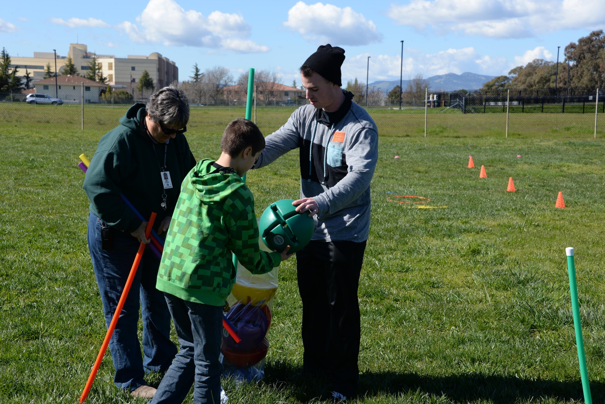 Senior Airman Bradley Chase, 60th Aerial Port Squadron cargo processer, helps set up a relay race during recess at Travis Elementary School at Travis Air Force Base, Calif., Feb. 27, 2017. Chase is one of nearly 70 Airmen who have volunteered at the school since Jan. 30. (U.S. Air Force photo/Tech. Sgt. James Hodgman/Released)