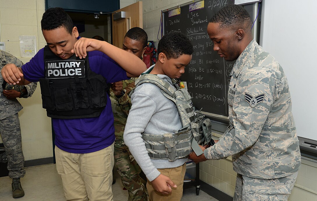 U.S. service members from Joint Base Langley-Eustis, Va., demonstrate the proper wear of protective vests to students during a career fair at Crittenden Middle School in Newport News, Va., Feb. 22, 2017. During the event, students asked questions about military careers, deployments and the education benefits that the military offers. (U.S. Air Force photo by Staff Sgt. Teresa J. Cleveland)