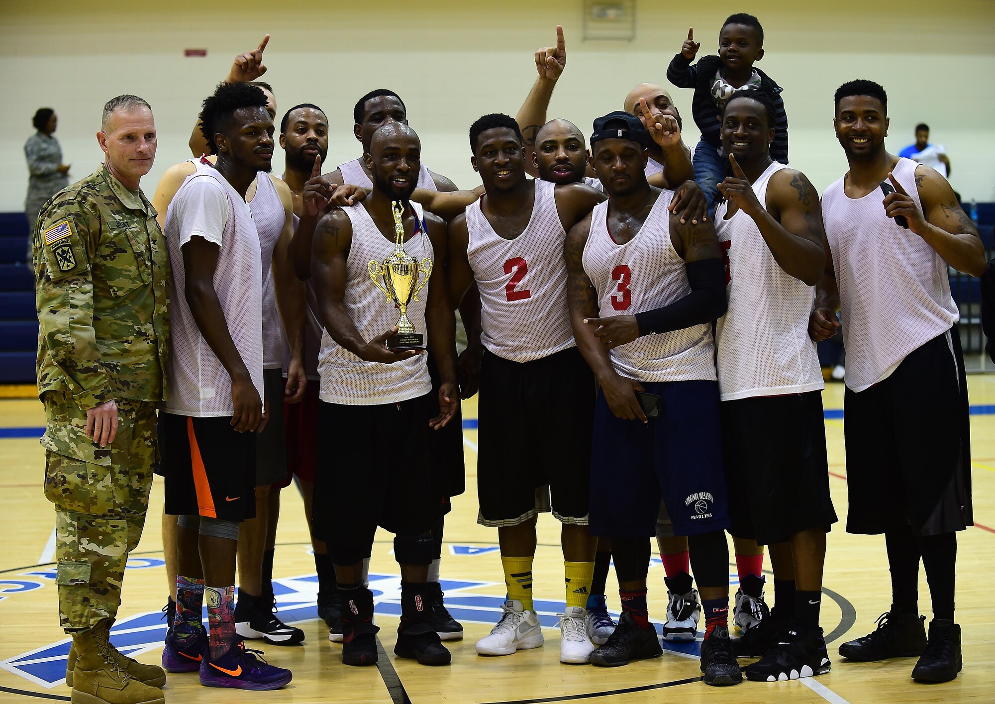 U.S. Army Col. Herbert Joliat, 633rd Air Base Wing incoming vice commander, poses with the winning team, the Ryan Center, after the 2016-2017 intramural basketball championship game at Joint Base Langley-Eustis, Va., Feb. 22, 2017. The team defeated the 633rd Force Support Squadron, after losing to them in the championship the prior year. (U.S. Air Force photo by Senior Airman Kimberly Nagle) 
