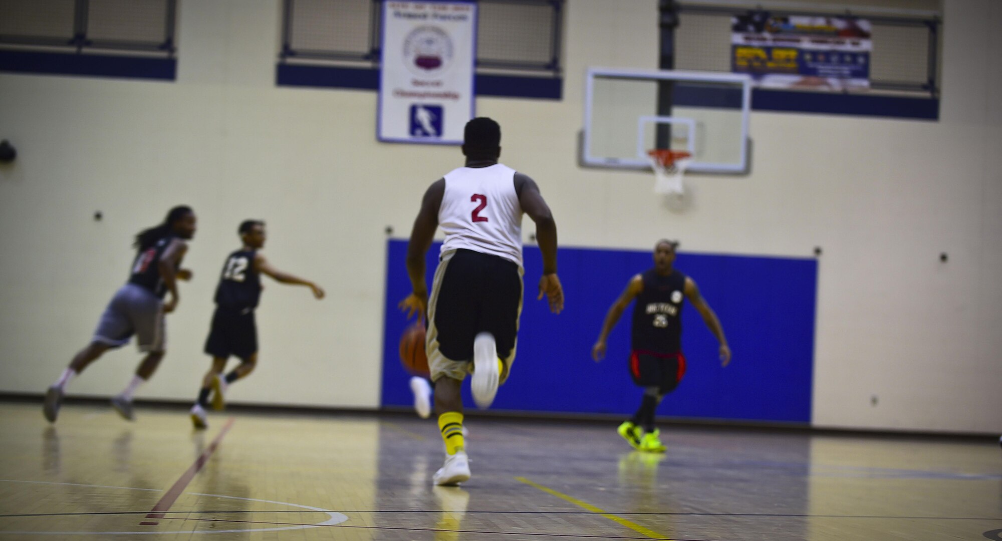 A member of the Ryan Center intramural basketball team dribbles the ball up the court during the 2016-2017 intramural basketball championship game at Joint Base Langley-Eustis, Va., Feb. 22, 2017. After two, 20-minute periods, the Ryan Center defeated the 633rd Force Support Squadron. (U.S. Air Force photo by Senior Airman Kimberly Nagle) 