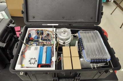 The Naval Medical Research Unit San Antonio-redesigned field portable ozone sterilizer chamber is housed in a ruggedized case and can be powered by rechargeable batteries or an external power source.  