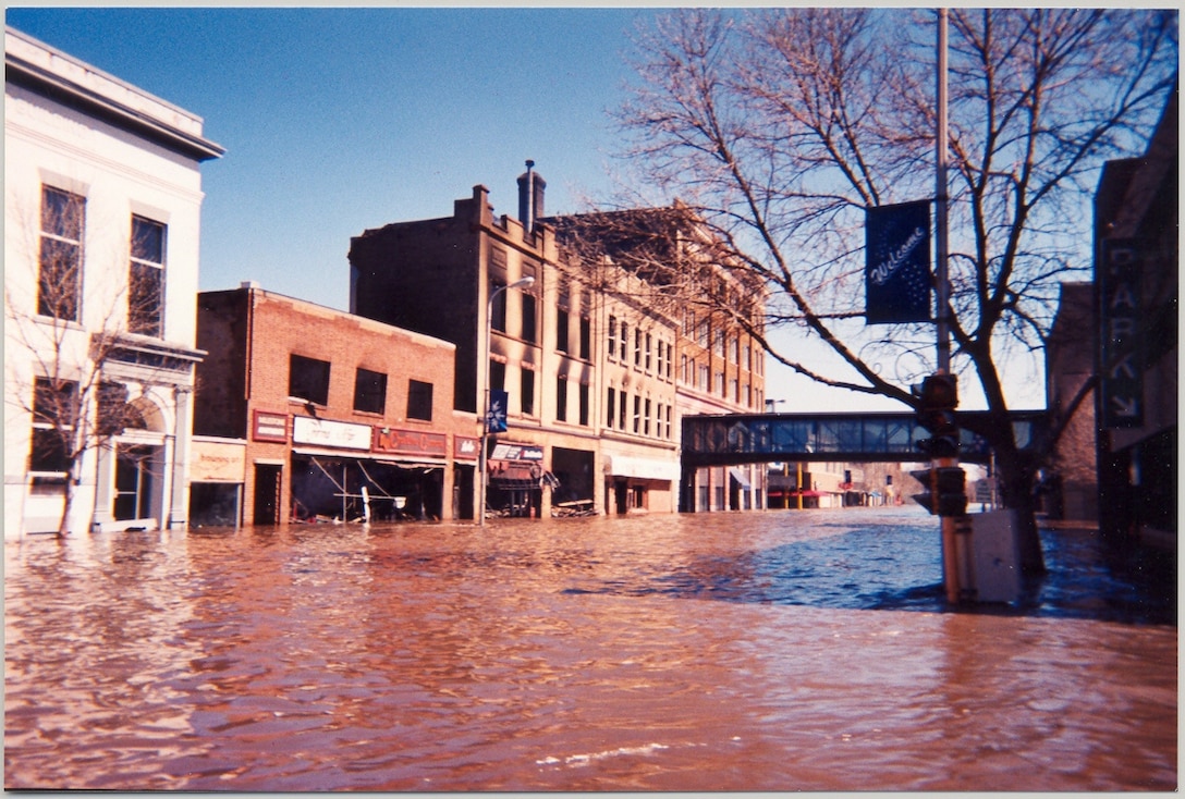 Floodwaters inundate 4th Street N., downtown Grand Forks, N.D., April 25, 1987. The photo is looking towards Demers Avenue. The second, third and fourth buildings on the left hand side were torn down after the flood.  --USACE St. Paul District file photo