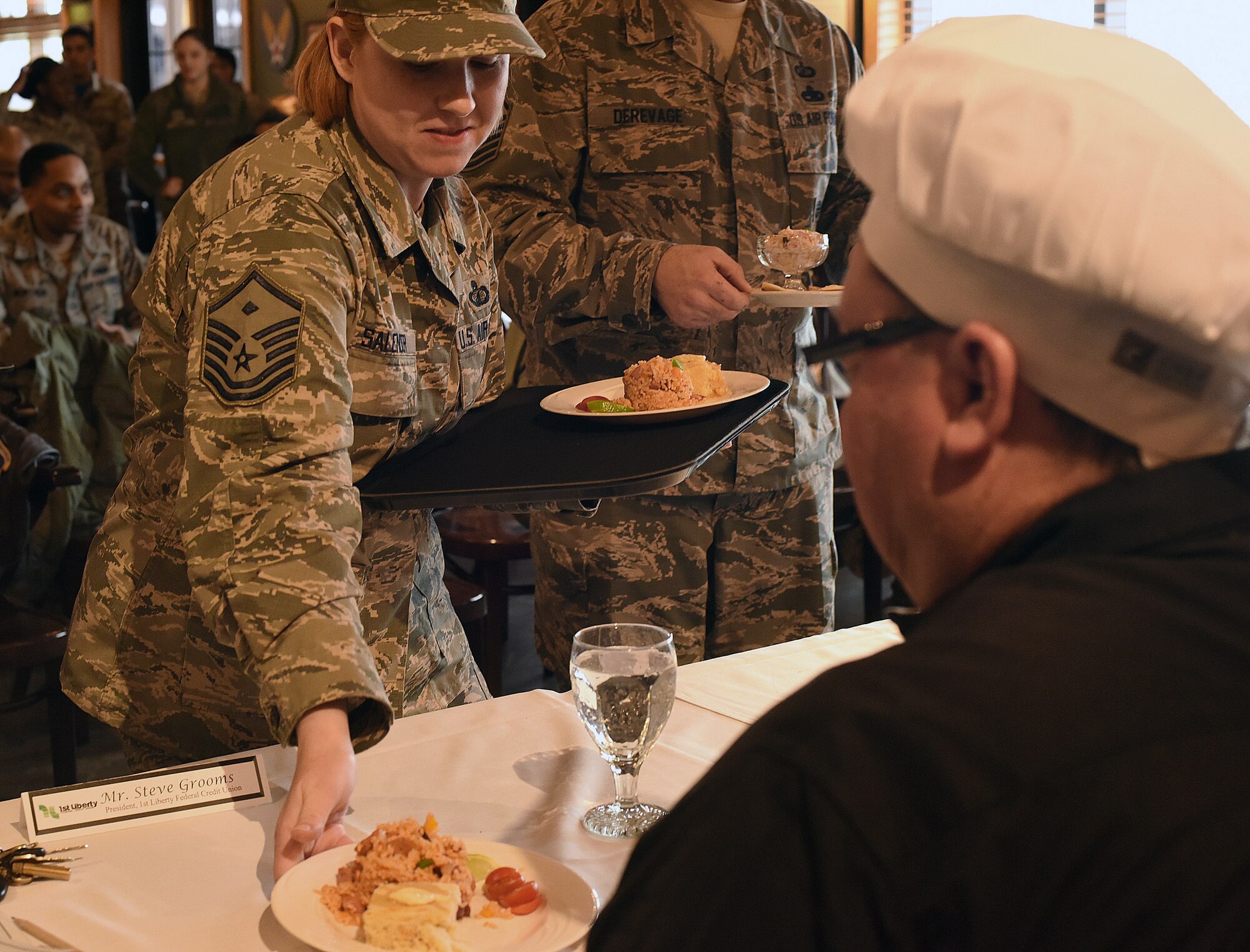 Master Sgt. Ruth Salender, 341st Operations Group first sergeant, places a prepared meal in front of one of the judges during the Warrior Chef competition Feb. 24, 2017, at Malmstrom Air Force Base, Mont. Dishes were assessed by a panel of judges based on taste, texture, creativity, and if they honored the theme ingredients and presentation. (U.S. Air Force photo/Senior Airman Jaeda Tookes)