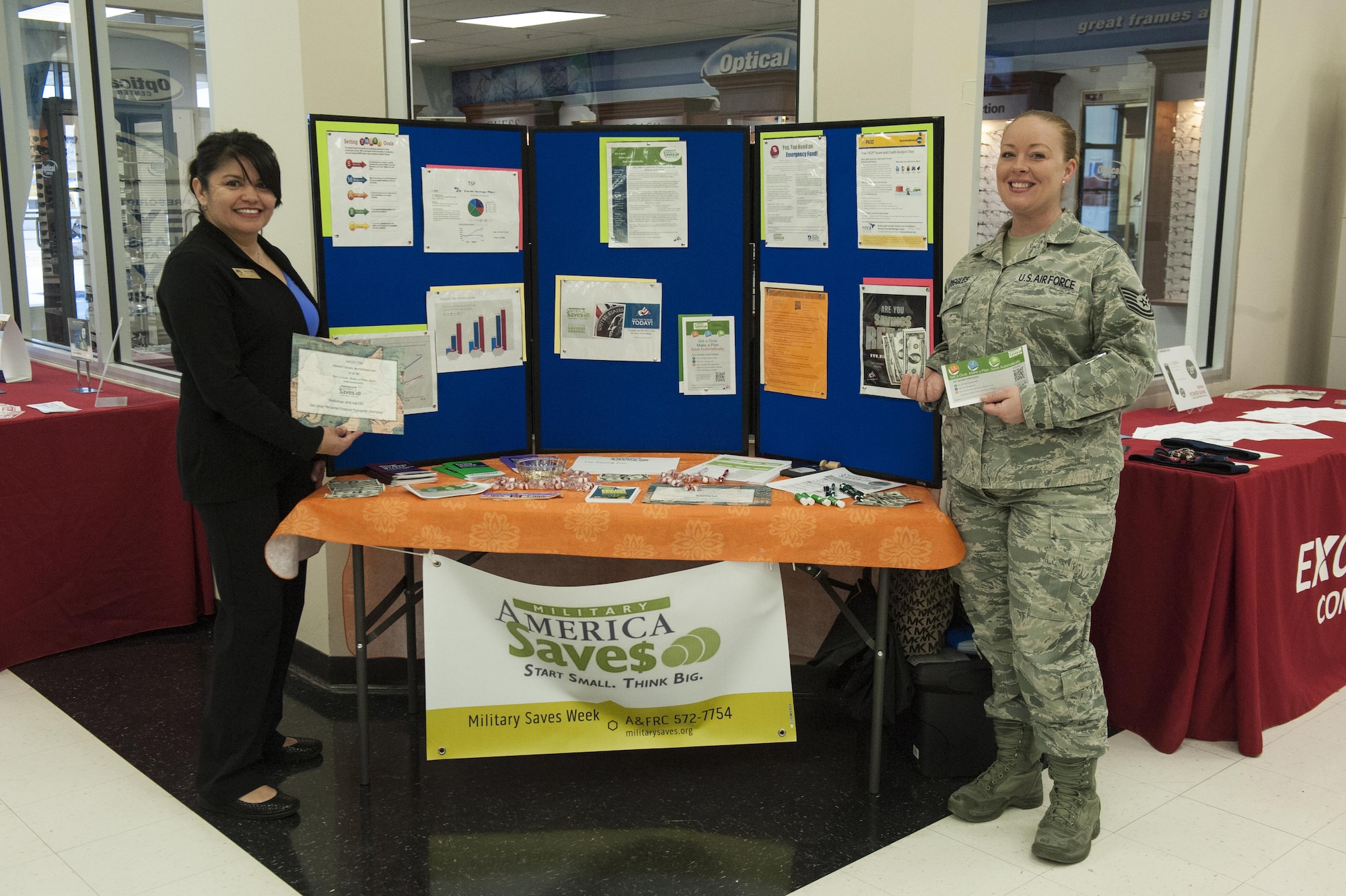 Maura Solis and Tech. Sgt. Melissa Striggles, from the Airman and Family Readiness Center, pose for a photo at Holloman Air Force Base, N.M., Feb. 27, 2017. All week long the AFRC will have representatives at the Base Exchange assisting Airmen with their savings plans and encouraging them to save throughout their career. (U.S. Air Force photo by Airman Ilyana A. Escalona)