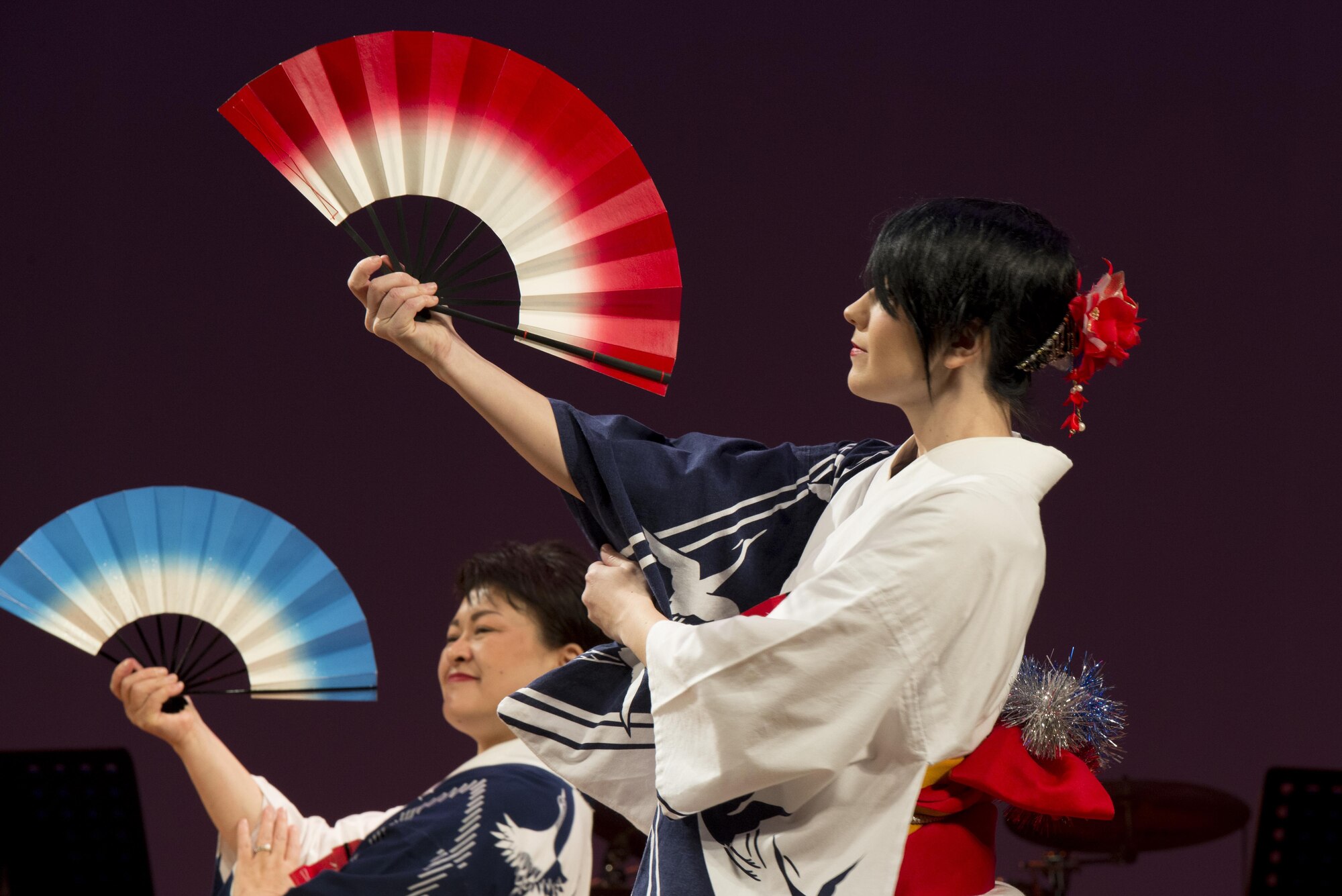 The Yokota Tanabata Dancers perform the Ehigasa dance on stage during the Japan-U.S. Joint Concert Feb. 18, 2017, at the Mizuho View Park Sky Hall in Mizuho, Tokyo, Japan. The Yokota Tanabata Dancers were formed in 1973 as a way to help promote good will and friendship. The colors of their yukata are U.S. Air Force themed blue and white with cranes to represent Yokota Air Base’s aircraft. (U.S. Air Force photo by Airman 1st Class Donald Hudson)