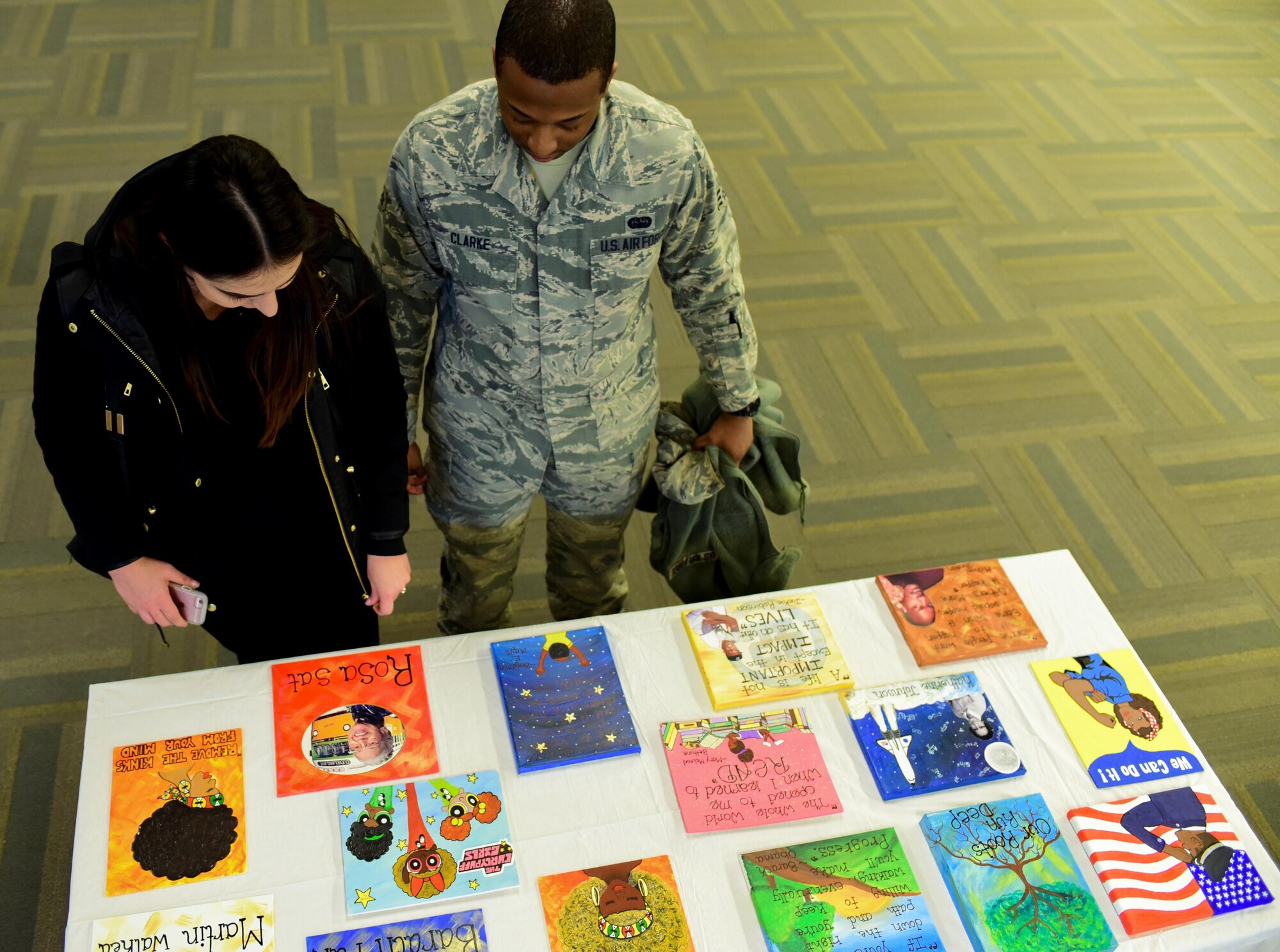 Samantha Clark and her husband Senior Airman Jason Clark, a unit deployment manager assigned to the 28th Communications Squadron, view art during the African American Heritage Month celebration inside the Deployment Center at Ellsworth Air Force Base, S.D., Feb. 28, 2017. The event showcased art submitted from Airmen, high school students and children from the Child Development Center. (U.S. Air Force photo by Airman 1st Class Randahl J. Jenson)     