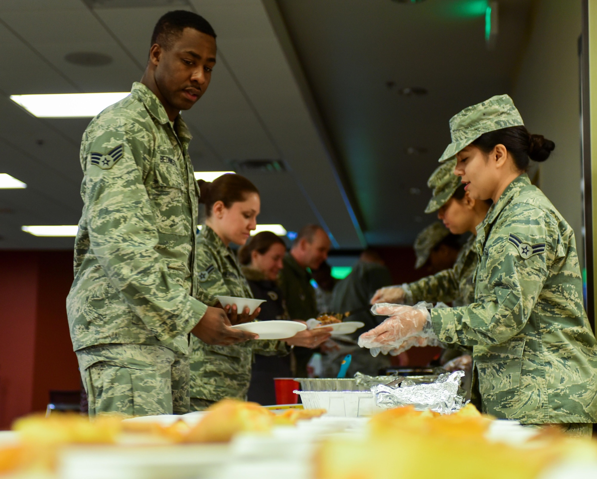 Airmen shuffle through a line, filling their plates with food during the African American Heritage Month celebration inside the Deployment Center at Ellsworth Air Force Base, S.D., Feb. 28, 2017. Shrimp jambalaya, grits and beans were just some of the kinds of food served. (U.S. Air Force photo by Airman 1st Class Randahl J. Jenson) 