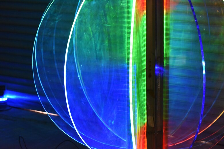 A large ball rigged with colorful lights illuminates the 379th Expeditionary Civil Engineer Squadron garage at Al Udeid Air Base, Qatar, Dec. 21, 2016. This ball was repaired by four Airmen with the 379th ECES so they could lower it on New Year’s Eve. (U.S. Air Force photo by Senior Airman Cynthia A. Innocenti)