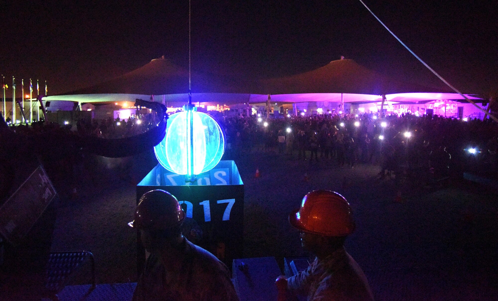 U.S. Air Force Airmen with the 379th Expeditionary Civil Engineer Squadron illuminate Memorial Plaza with a large ball rigged with colorful lights at Al Udeid Air Base, Qatar, Dec. 31, 2016. This ball was repaired by four Airmen with the 379th ECES so they could lower it on New Year’s Eve. (U.S. Air Force photo by Senior Airman Cynthia A. Innocenti)