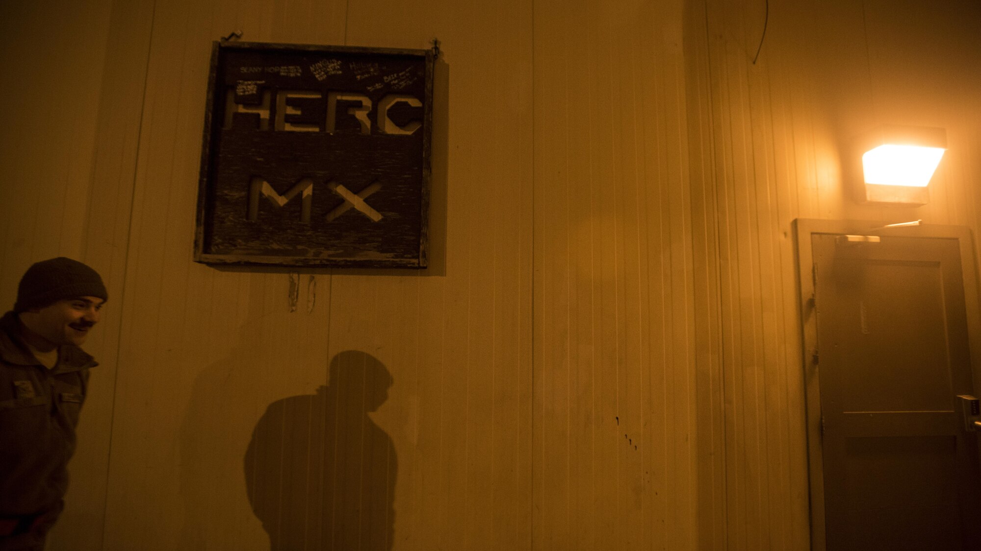 Senior Airman Thomas Budd, 455th Expeditionary Aircraft Maintenance Squadron crew chief, walks into the C-130J Hercules aircraft maintenance unit Dec. 9, 2016 at Bagram Airfield, Afghanistan. The C-130 AMU component of the 455th EAMXS is responsible for upkeep and repair of Bagram’s fleet of C-130J aircraft. (U.S. Air Force photo by Staff Sgt. Katherine Spessa)