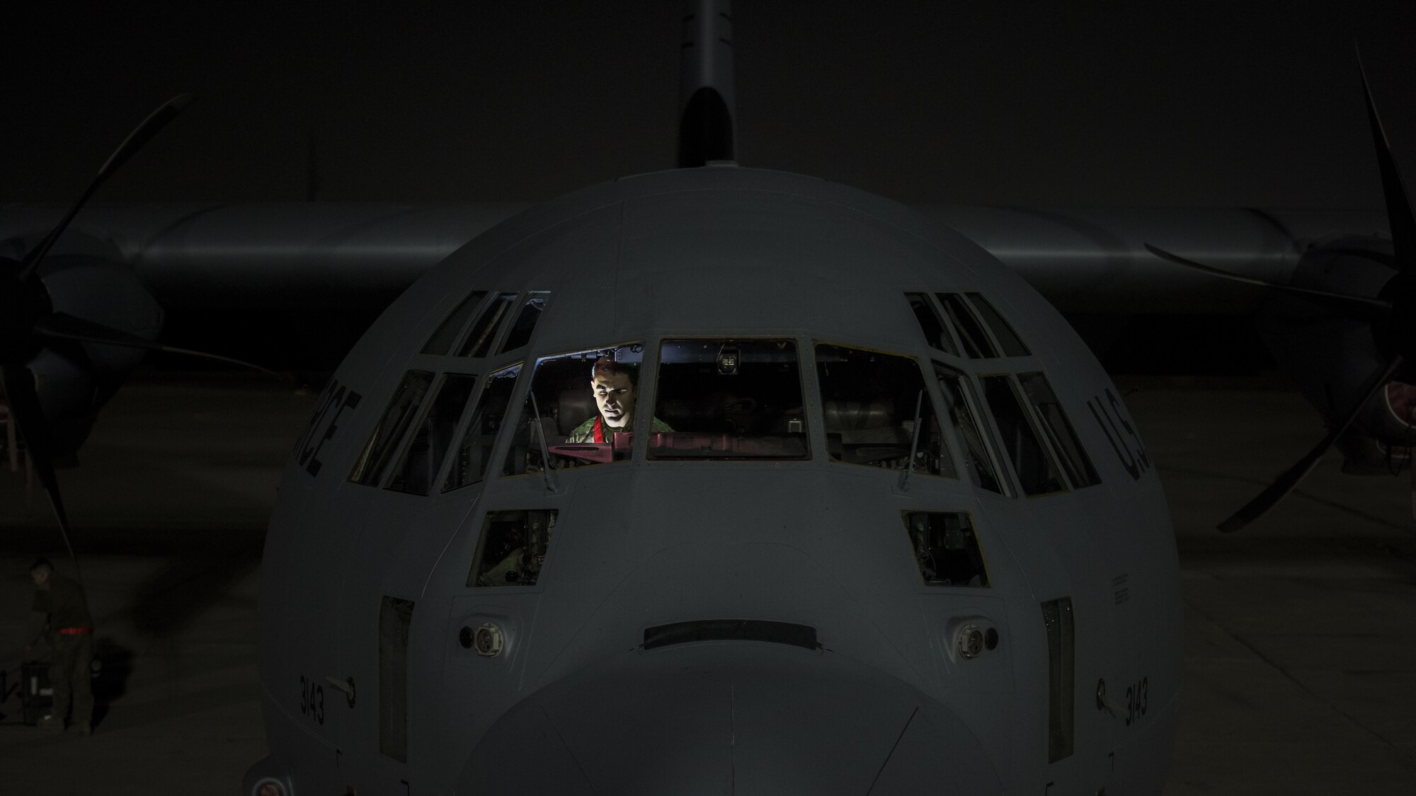Senior Airman Dylan Robinson, 455th Expeditionary Aircraft Maintenance Squadron crew chief, sits in the flight deck of a C-130J Hercules during an inspection Dec. 9, 2016 at Bagram Airfield, Afghanistan. C-130J major system improvements include an advanced two-pilot flight station with fully integrated digital avionics, color multifunctional liquid crystal and head-up displays and state-of-the-art navigation that includes a dual inertial navigation system and GPS. (U.S. Air Force photo by Staff Sgt. Katherine Spessa)