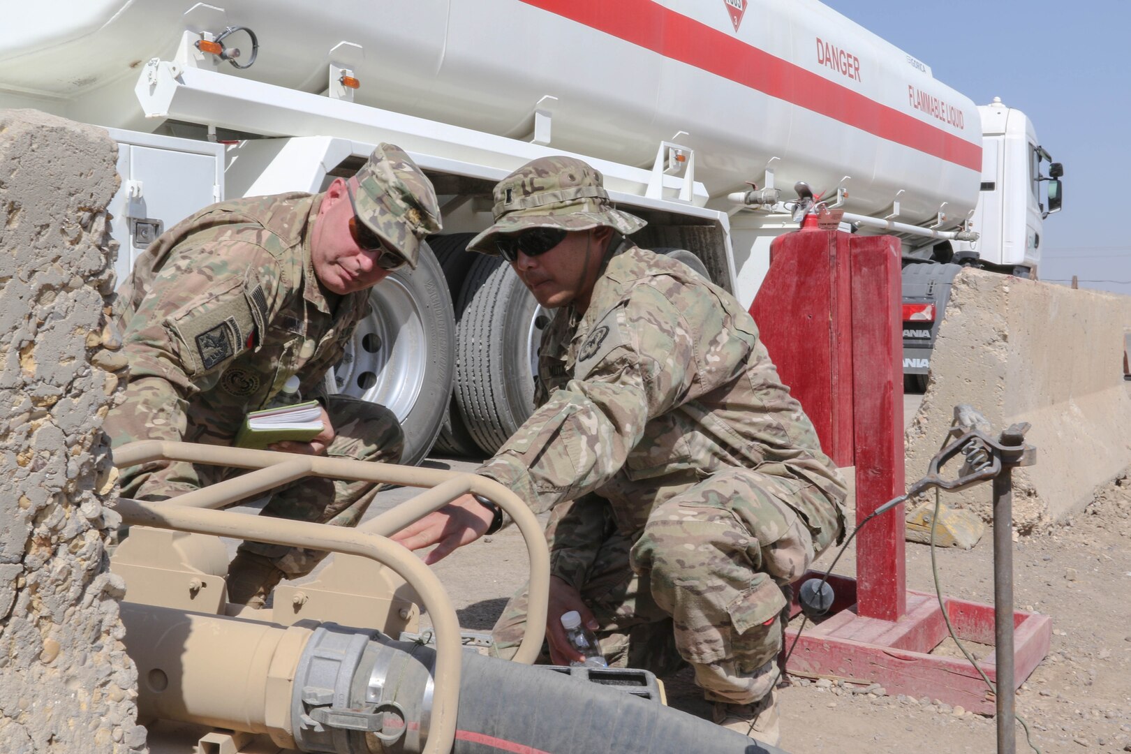 Maj. William Rozar, the deputy Inspector General for the 1st Theater Sustainment Command Operational Command Post, and 1st Lt. Brian Mutas, the petroleum operations officer for the Nevada National Guard’s 17th Sustainment Brigade, inspect the fuel gauge on a tanker truck downloading fuel at a forward operating base in Iraq, recently. U.S. Army Central uses forward logistical elements to maintain fuel farms under contract with U.S. Army logistical specialists called contract representatives to ensure the operations is being conducted to the Army standard. (U.S. Army photo by Sgt. Brandon Hubbard, USARCENT Public Affairs)