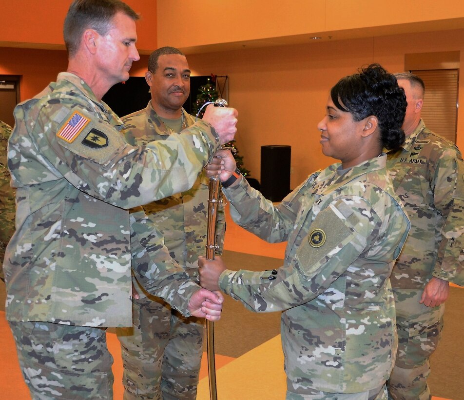 Col. Toni A. Glover, 650th Regional Support Group commander, passes the noncommissioned officer sword, which is used to signify the transfer of responsibility, to Command Sgt. Maj. Darin S. Daniels, a Mesa, Arizona resident, in a change of responsibility ceremony at the George W. Dunaway Army Reserve Center in Sloan, Nevada December 18. In his civilian capacity, Daniels serves as a Firefighter/Paramedic on the Phoenix Fire Department.