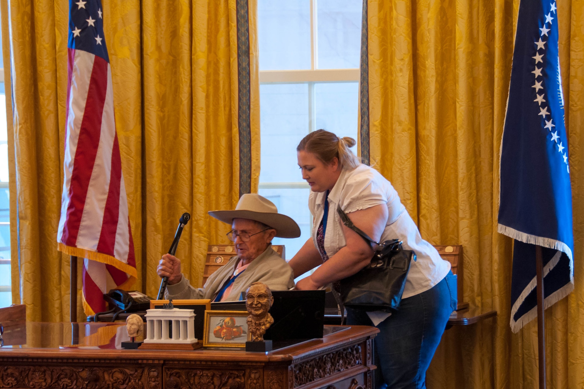 Robin B. Tolson, a tail gunner in the B-24 Liberator during World War II, gets settled in for a picture behind the president’s desk in the Oval Office at the Clinton Library, Little Rock, AR on May 20, 2016. The Clinton Library was one of the tours set up for the World War II veterans during the Annual 489th Bomb Group Reunion. Tolson was part of the 489th during World War II. (U.S. Air Force photo by Master Sgt. Laura Siebert/Released)