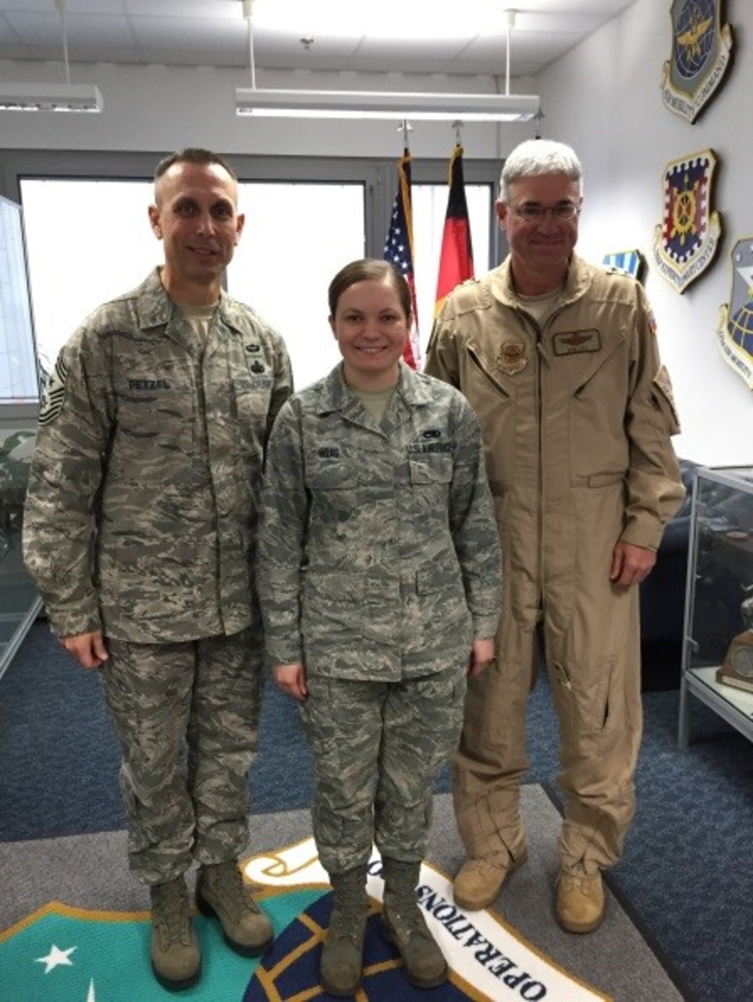 Senior Airman Paige Hoag poses with Chief Master Sgt. Todd Petzel, 18th Air Force Command Chief, and Lt. Gen. Samuel D. Cox, 18th Air Force commander after a coining ceremony at Ramstein Air Base, Germany Dec. 19. (Courtesy photo)