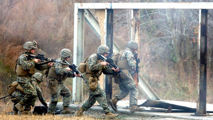 Marines practice assaulting through a doorway after setting off an explosive charge for an urban assault breaching range during a deployment for training exercise at Fort Pickett, Va., Dec. 8, 2016. The training was a learning experience for the Marines to improve their assault breaching skills. The Marines are with Charlie Company, 2nd Combat Engineer Battalion. 