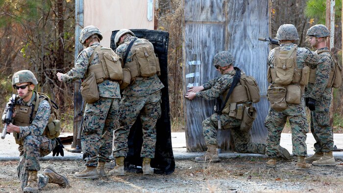 Marines place a detonation cord linear charge on a door for an urban assault breaching range during a deployment for training exercise at Fort Pickett, Va., Dec. 8, 2016. The purpose of the training was to prepare the Marines for real-world scenarios in assault breaching. The Marines are with Charlie Company, 2nd Combat Engineer Battalion. 