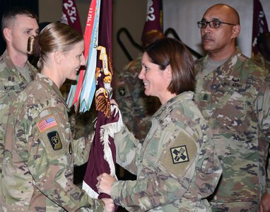 Command Sgt. Maj. Jody L. Stanley (center), incoming command sergeant major for the 232nd Medical Battalion at Joint Base San Antonio-Fort Sam Houston, accepts the guidon from Lt. Col. Caryn R. Vernon (left), 232d Med. Bn. commander, while outgoing battalion Command Sgt. Maj. Richard A. Shanklin (right) looks on. The battalion is the largest training battalion in the U.S. Army, responsible for training Health Care Specialist, 68W, the second largest Military Operational Specialty in the U.S. Army.