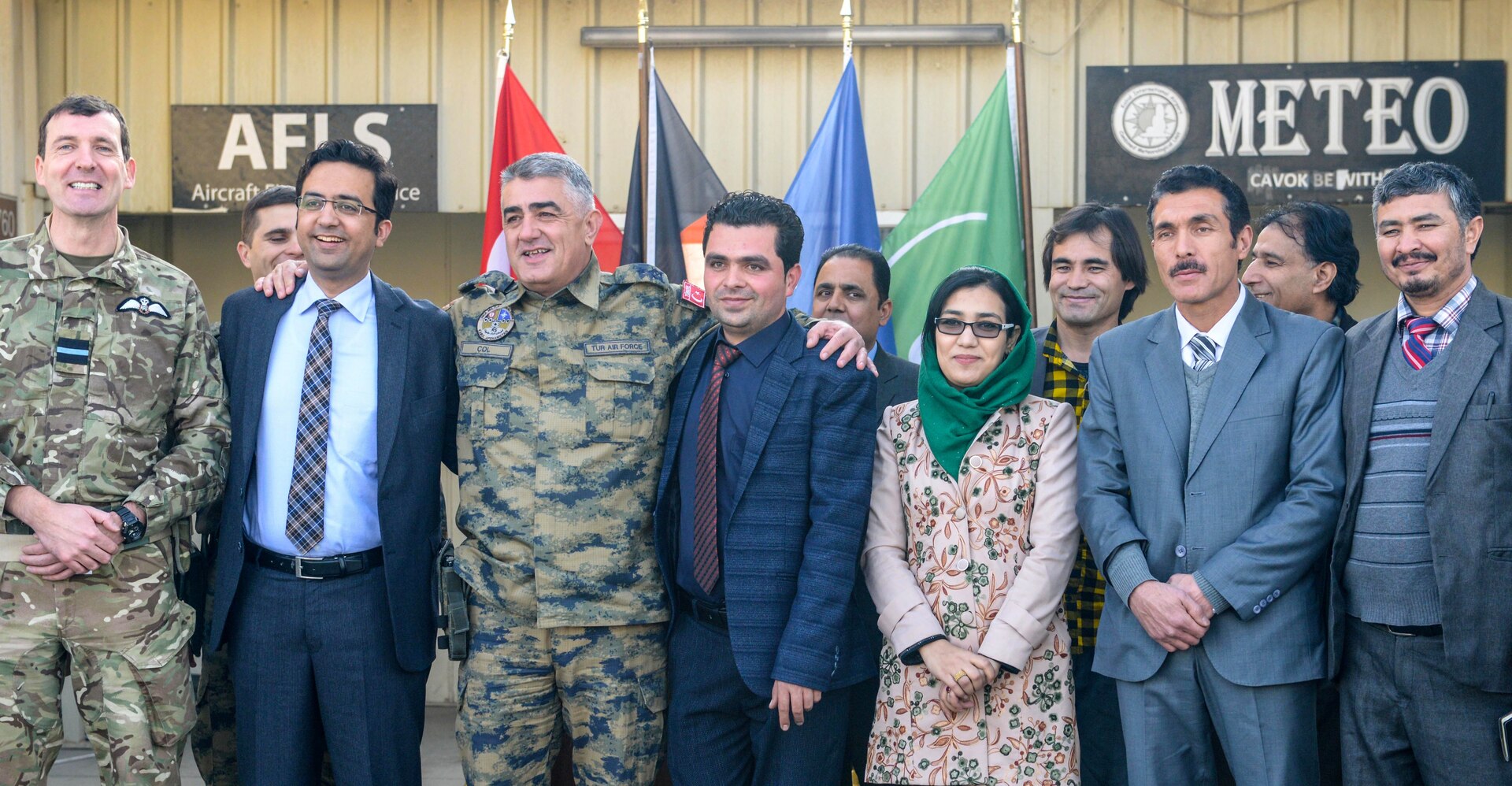 Members of NATO Air Command - Afghanistan and the Afghan Civil Aviation Authority stand together during a group photo at Hamid Karzai International Airport, Kabul, Afghanistan, Jan. 1, 2017. The military and civilian aviation personnel held a ceremony which marked the integration of Afghan meteorologists into the NATO meteorology office at the busiest airport in Afghanistan. (NATO photo by Kay M. Nissen)