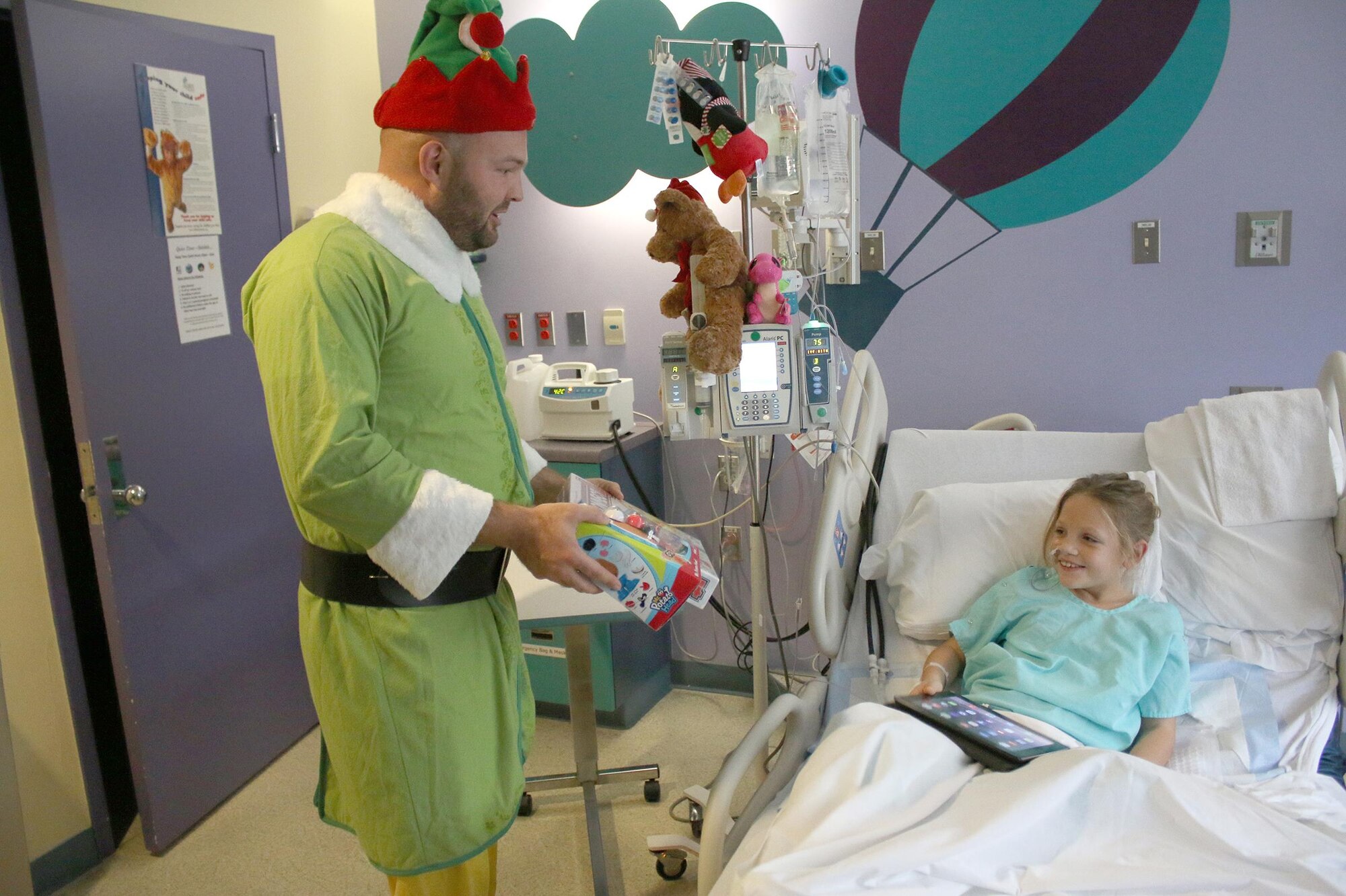 Tech. Sgt. Jordan West, 87th Aerial Port Squadron, delivers a gift to a child at Dayton Children’s Hospital December 16, 2016. More than 15 members of the 87th APS participated in the unit's 26th annual event by giving out toys and spreading holiday cheer to the children. (U.S. Air Force photo/Tech. Sgt. Patrick O'Reilly)