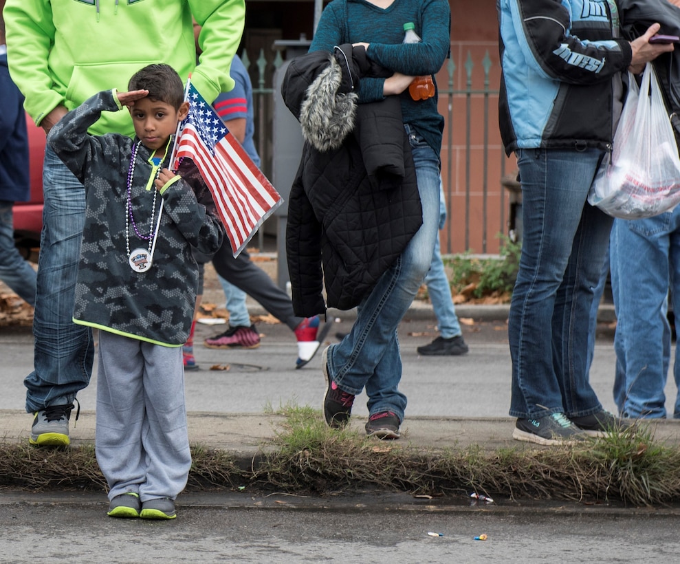 A young parade attendee salutes as members of the U.S. Air Force Honor Guard march by during the Allstate Sugar Bowl New Years Eve Parade in New Orleans, LA, Dec. 31, 2016.  More than 90 members of the USAF HG performed in the event, which was held in celebration of the Allstate Sugar Bowl, where the Auburn Tigers and Oklahoma Sooners will battle for the cup, Jan 2., 2017.