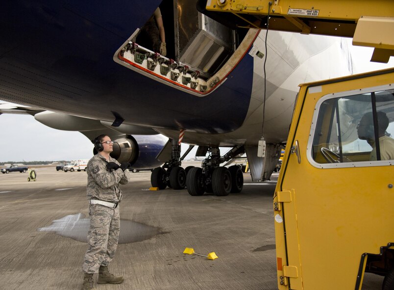 Tech. Sgt. Steven Keegan, air operations supervisor, 96th Logistics Readiness Squadron directs Staff Sgt. Devoice Miller, 96 LRS air operation journeymen, while he aligns the conveyer belt with the aircraft loading bay Dec. 29 on the flight line at Eglin Air Force Base, Fla. The crew of five loadmasters, also known as the ‘port dogs’ loaded nearly 82,000 pounds of equipment in less than two hours. The equipment belonged to the Niceville High School band students and staff members for their performance in the 2017 Tournament of Roses Parade in California. (U.S. Air Force photo/Kristin Stewart)