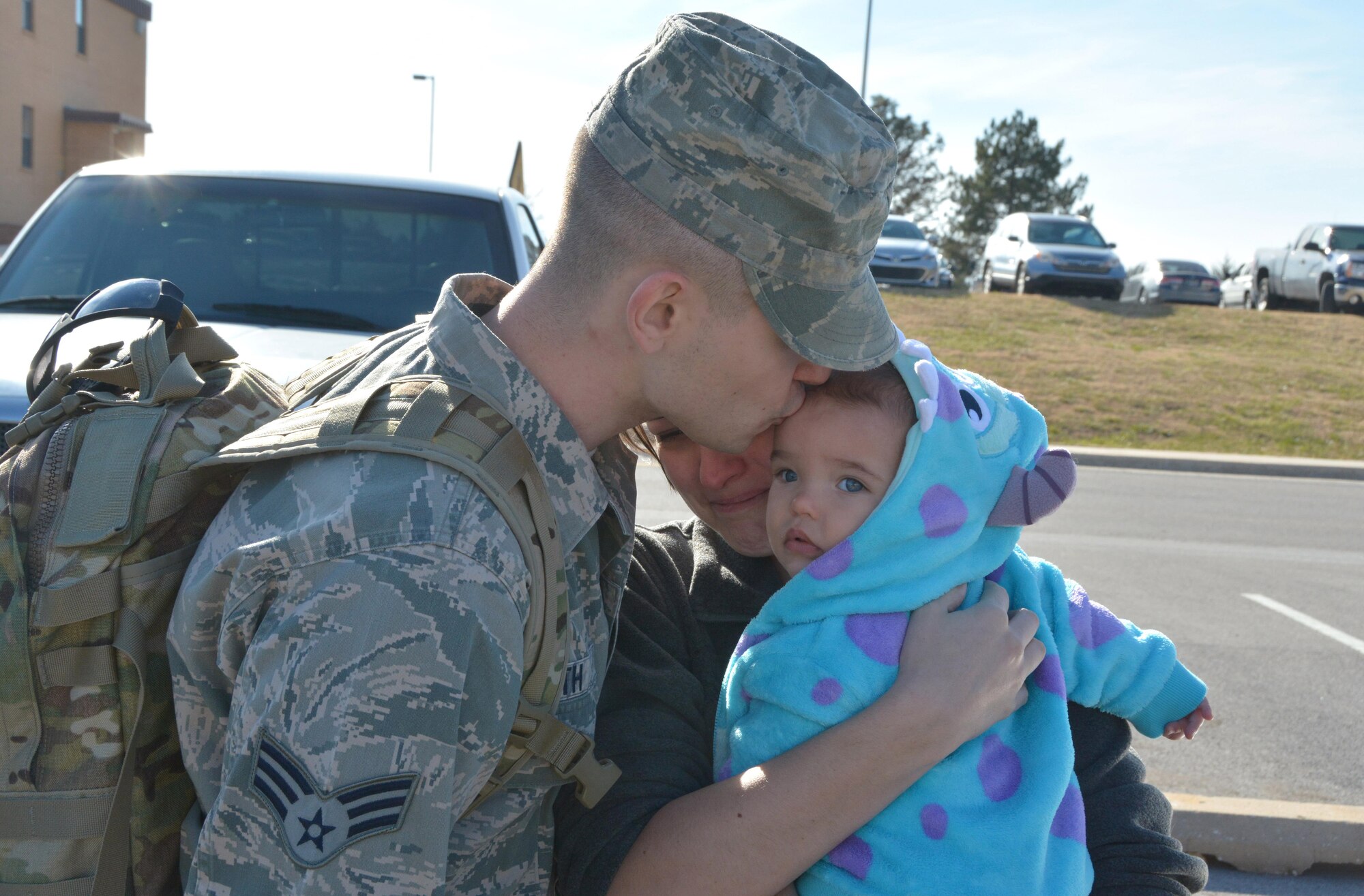 Senior Airman Harlan Smith, 507th Aircraft Maintenance Squadron kisses his daughter and embraces his girlfriend prior to departing for a deployment to Incirlik Air Base, Turkey. Smith joined 93 other Citizen Airmen from the 507th Air Refueling Wing at Tinker Air Force Base, Oklahoma who deployed prior to the holiday December 13, 2016.  (U.S. Air Force Photo/Maj. Jon Quinlan)