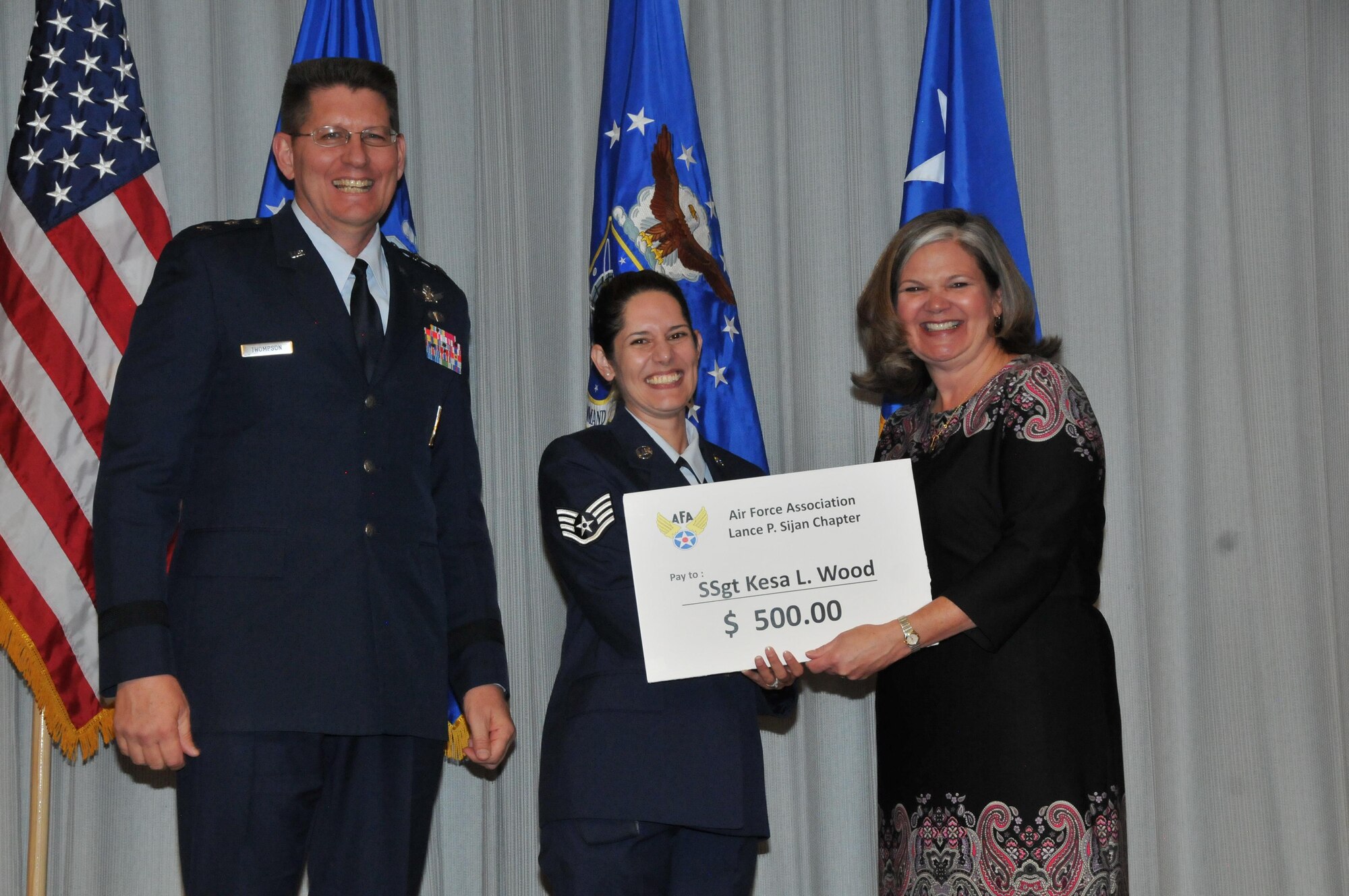 PETERSON AIR FORCE BASE, Colo. – Staff Sgt. Kesa Wood, 16th Space Control Squadron NCO in charge of current operations at Peterson Air Force Base, Colorado, receives a prize check from Kristen Christy, president of the Air Force Association Lance P. Sijan Chapter, and Maj. Gen. David Thompson, vice commander of Air Force Space Command, for being the 2016 Gen. Bernard A. Schriever Memorial Essay Contest winner for the Airman/NCO division. (Courtesy photo)