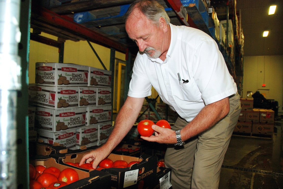 DLA Troop Support’s Ken Wilmoth, who leads one of six garrison feeding teams that carry out the DoD Fresh Fruit and Vegetable Program, inspects tomatoes destined for elementary schools at the prime vendor’s location in Greensboro, North Carolina. 
