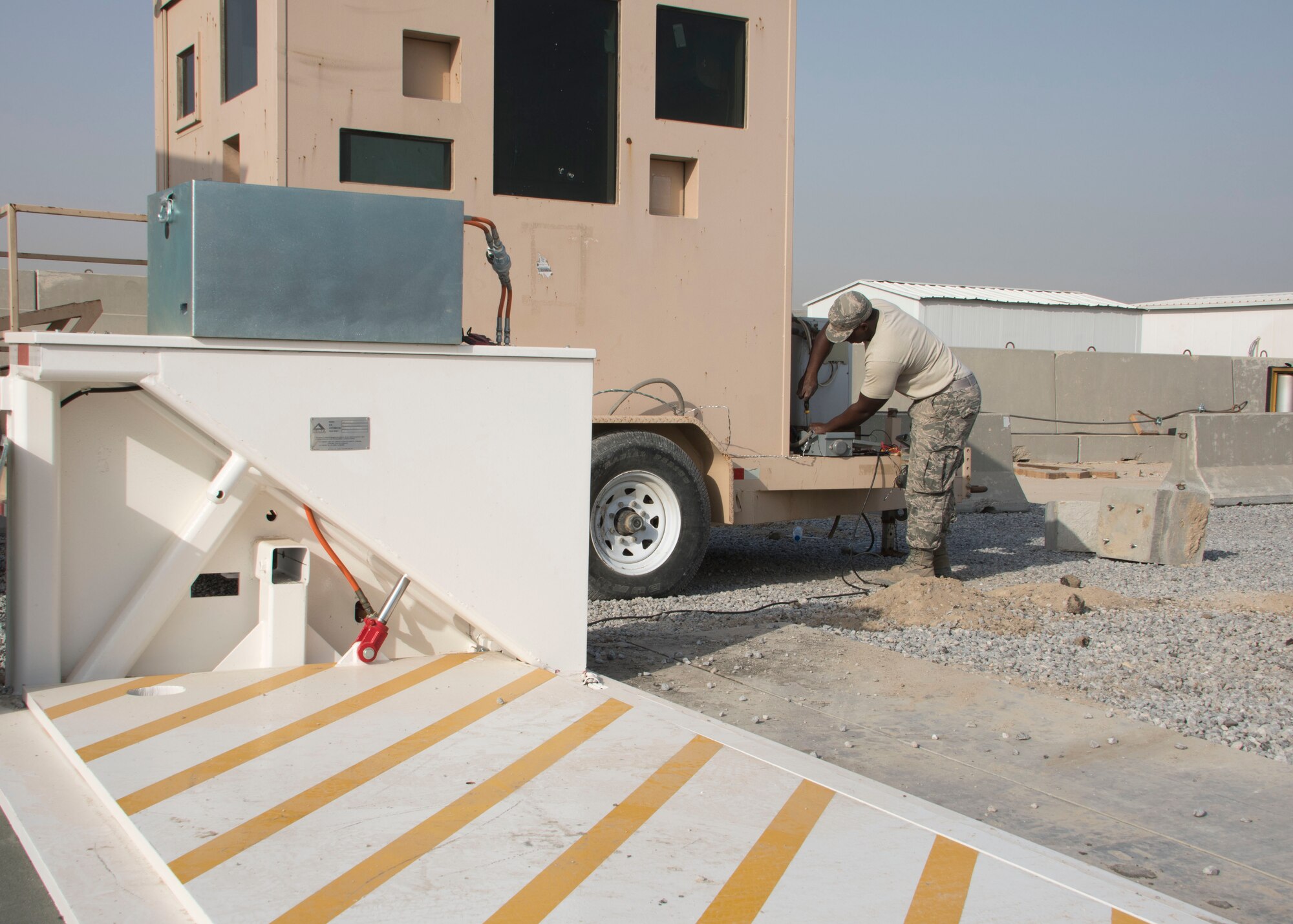 Senior Airman Doug Sampson from the 387th Expeditionary Support Squadron wires power to a guard shack at a new entry control point an undisclosed location in Southwest Asia Dec. 30, 2016. In addition to wiring power to the guard shack, the 387th ESPTS was also able to install power to the barricades installed at the new ECP. (U.S. Air Force photo/Senior Airman Andrew Park)