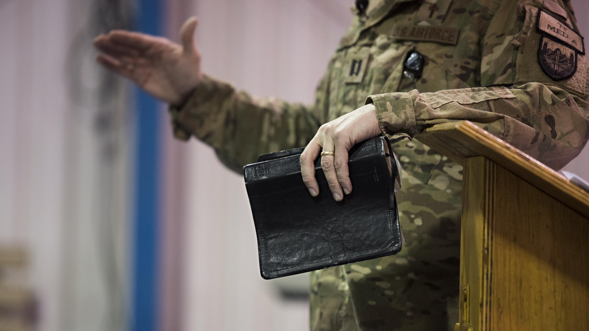 Chaplain (Capt.) Timothy Tangen, 455th Air Expeditionary Wing chaplain, holds a bible while preaching during a service Jan. 1, 2016 at the Warrior Chapel, Bagram Airfield, Afghanistan. During the service, Tangen spoke about the importance of spiritual resilience over the new year. (U.S. Air Force photo by Staff Sgt. Katherine Spessa)