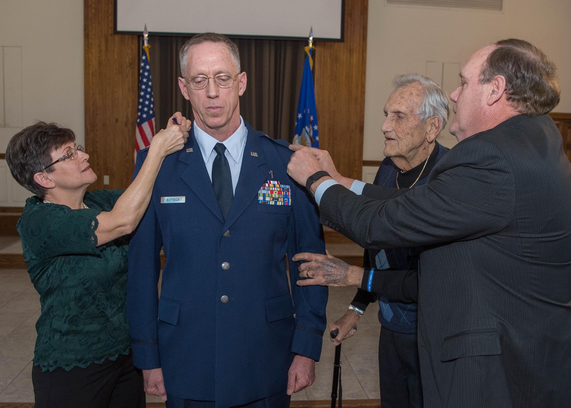Chaplain (Col.) David L. Buttrick, 66th Air Base Group chaplain, has the rank of colonel pinned on his uniform by his wife, Sharon, his father, U.S. Air Force retired Lt. Col. Lewis Buttrick, and his older brother, U.S. Air Force retired Lt. Col. Brandon Buttrick during a ceremony at the chapel Dec. 30. Buttrick is the installation's senior chaplain. (U.S. Air Force photo by Jerry Saslav)