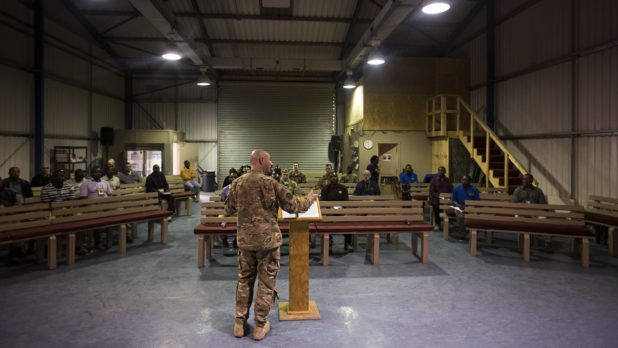 Churchgoers listen to Chaplain (Capt.) Timothy Tangen, 455th Air Expeditionary Wing chaplain, preach during a service Jan. 1, 2016 at the Warrior Chapel, Bagram Airfield, Afghanistan. Service members, Defense Department civilian employees and contractors attend chapel at one of several locations around Bagram to maintain spiritual resilience while deployed. (U.S. Air Force photo by Staff Sgt. Katherine Spessa)