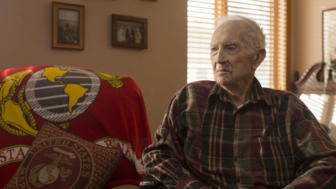 Retired 1st Lt. John J. O’Leary, a Marine veteran of World War II, looks at pictures on his dresser at the Evergreen Community of Johnson County, Olathe, Kan., Dec. 21, 2016. O’Leary fought on Guam and witnessed the bombardment of Iwo Jima as a member of 3rd Joint Assault Signal Company. He celebrated his 100th birthday on Dec. 23. 