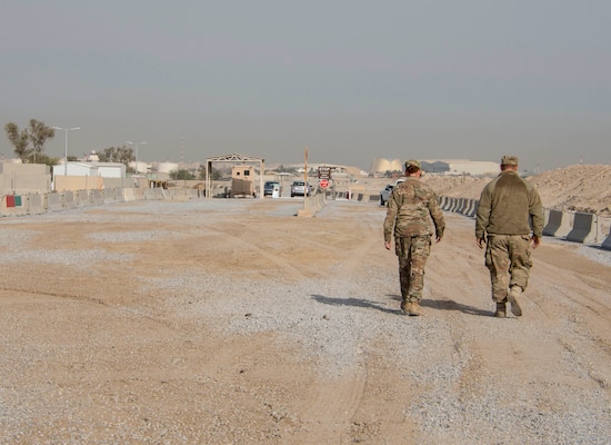 Tech. Sgt. Lora Ramos, left, and Senior Airman William Klein, right, of the 557th RED HORSE walk down a newly built road at an undisclosed location in Southwest Asia Dec. 30, 2016. The 387th Air Expeditionary Group enlisted the help of various squadrons and groups to complete the new road and entry control point in approximately four months. (U.S. Air Force photo/Senior Airman Andrew Park)