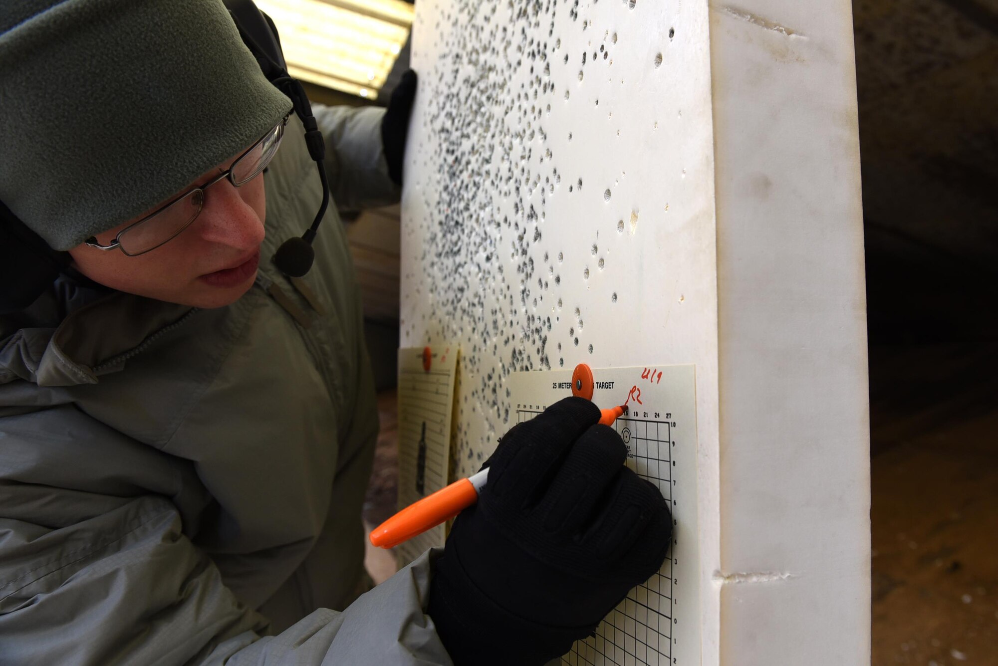 U.S. Air Force Senior Airman Shelby Bibb, 19th Security Forces Squadron combat arms instructor, reviews a target to determine firing accuracy during a Combat Arms Training and Maintenance session Dec. 14, 2016, at Little Rock Air Force Base, Ark. The 19th SFS CATM instructor team consists of seven Airmen who work together to train more than 600 Airmen annually. (U.S. Air Force photo by Airman 1st Class Kevin Sommer Giron)