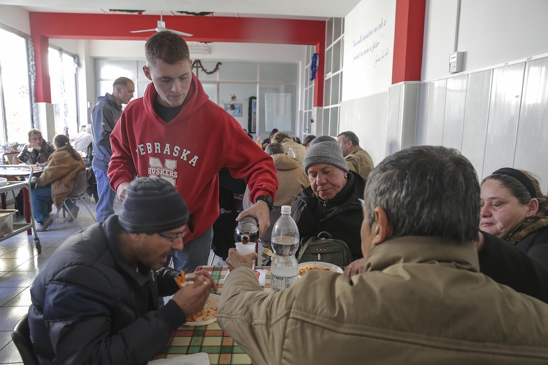 Marine Corps Lance Cpl. Kai Wendland pours a beverage at a soup kitchen in Catania, Italy, Dec. 29, 2016. Wendland is a combat engineer assigned to Special Purpose Marine Air-Ground Task Force Crisis Response Africa. Marine Corps photo by Cpl. Alexander Mitchell