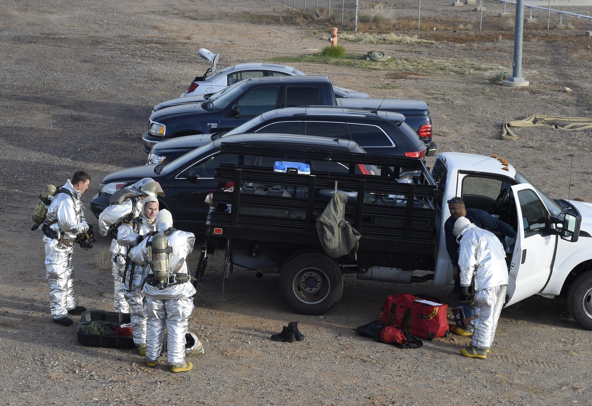 Firefighters with the 56th Civil Engineer Squadron and Gila Bend Fire Department suit up in proximity suits prior to training Dec. 7, 2016, at Luke Air Force Base, Ariz. The firefighters were training on responding to an aircraft fire. (U.S. Air Force photo by Senior Airman James Hensley)