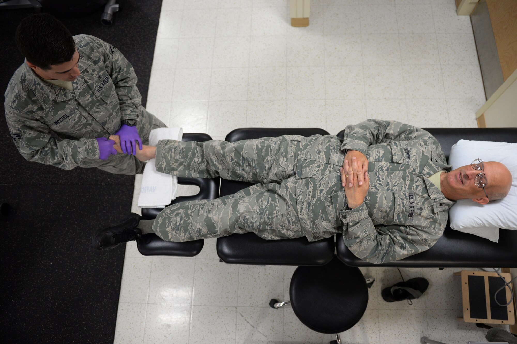 Senior Airman Wesley McCool, 81st Surgical Operations Squadron physical medical technician, works on Chaplain (Col.) David Terrinoni, 81st Training Wing chaplain, in the physical therapy department April 7, 2016, Keesler Air Force Base, Miss. McCool is working on Terrinoni’s toe mobilization by pulling his toe away, then curling and extending the toe to improve its range of motion. (Air Force Photo by Airman 1st Class Travis Beihl)