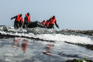 Suriname special operations competitors carry a Zodiac craft to the shore of the Pacific Ocean during a water event May 6, as part of Fuerzas Comando 2016 in Ancon, Peru. Fuerzas Comando is a U.S. Southern Command sponsored multinational special operations skills competition. (U.S. Army photo by Staff Sgt. Chad Menegay/Released)